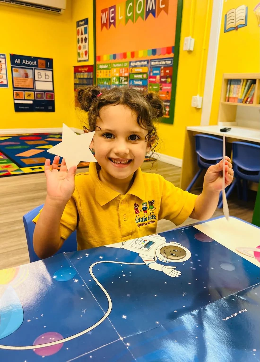 A child happily building a tower of wooden blocks at Kiddie Kids